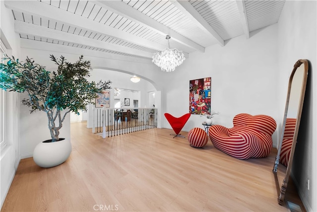 living area with hardwood / wood-style flooring, wood ceiling, beam ceiling, and a notable chandelier