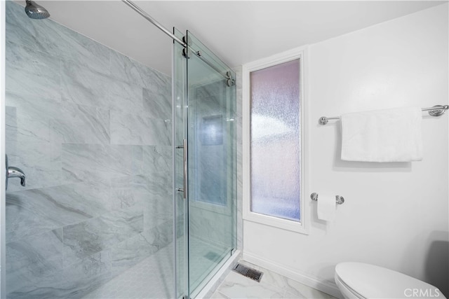 bathroom with a shower with shower door and toilet