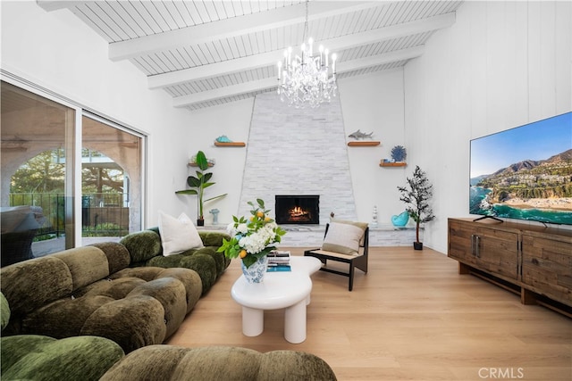 living room with an inviting chandelier, high vaulted ceiling, light hardwood / wood-style floors, a stone fireplace, and beamed ceiling