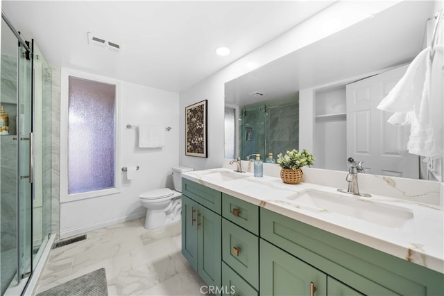 bathroom with vanity, a shower with door, and toilet