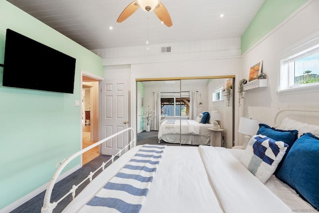 carpeted bedroom featuring ceiling fan and a closet