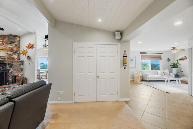 carpeted entrance foyer with ceiling fan and vaulted ceiling