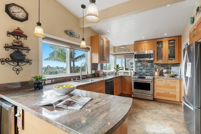 kitchen with sink, appliances with stainless steel finishes, hanging light fixtures, decorative backsplash, and kitchen peninsula