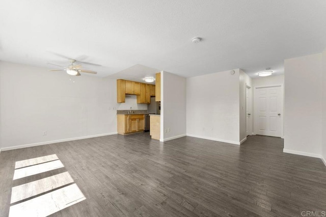 unfurnished living room featuring ceiling fan, sink, and dark hardwood / wood-style flooring