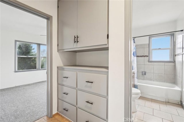 full bath with toilet, shower / tub combo, and tile patterned flooring