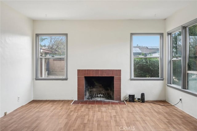 unfurnished living room with a fireplace and wood finished floors