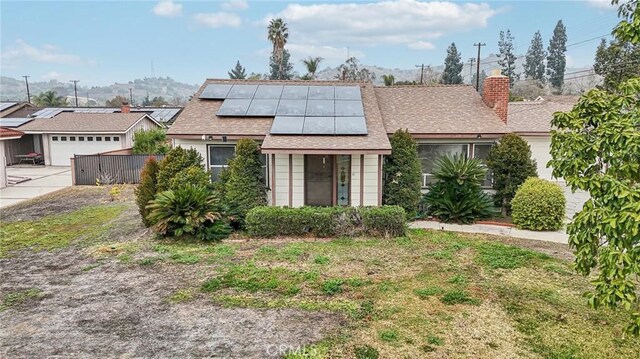 view of front facade featuring a garage and solar panels