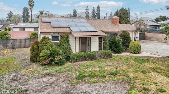 view of front of home with a front lawn and solar panels