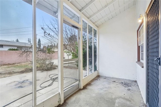 unfurnished sunroom featuring lofted ceiling with beams and wooden ceiling