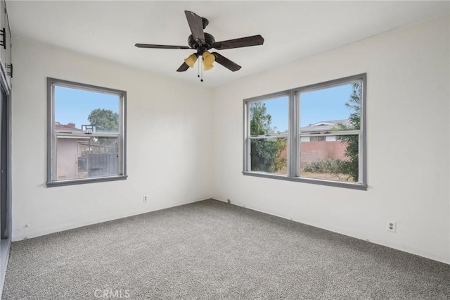 empty room with carpet floors, a wealth of natural light, and ceiling fan