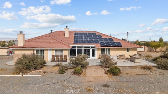 back of property featuring an outdoor living space, a patio, and solar panels