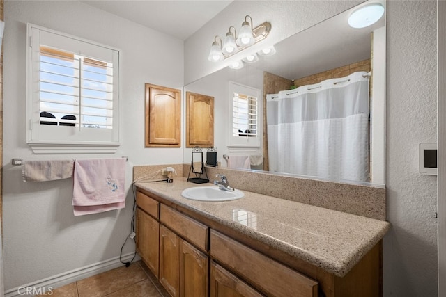 bathroom with tile patterned flooring, vanity, plenty of natural light, and walk in shower