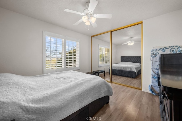 bedroom featuring ceiling fan, hardwood / wood-style floors, a textured ceiling, and a closet