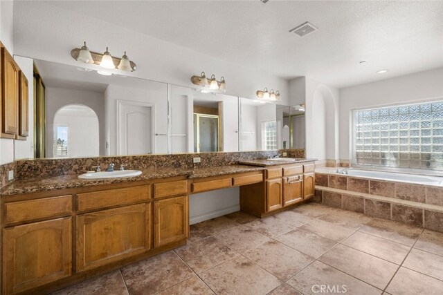 bathroom with tile patterned flooring, vanity, and separate shower and tub