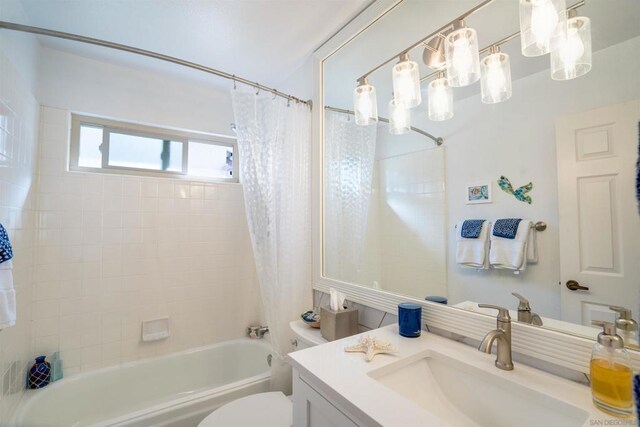 full bathroom with vanity, shower / bath combo with shower curtain, and toilet