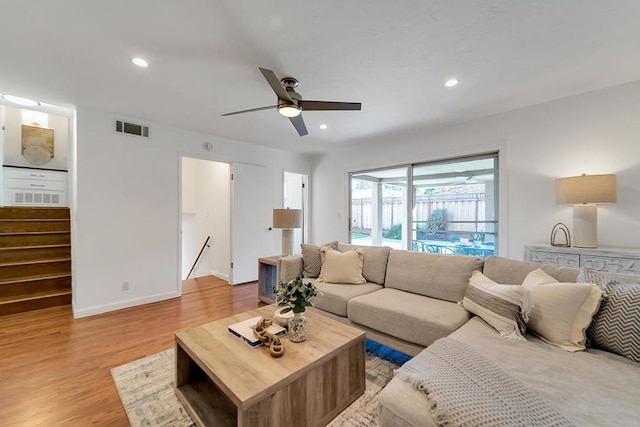 living room with light hardwood / wood-style floors and ceiling fan