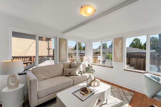 sunroom / solarium featuring beamed ceiling