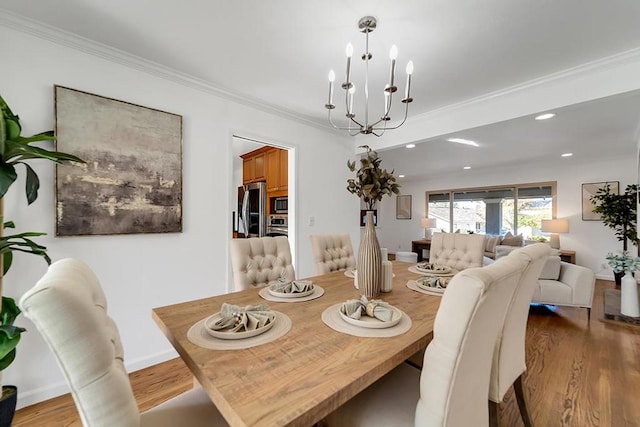 dining area featuring ornamental molding, a chandelier, and light wood-type flooring