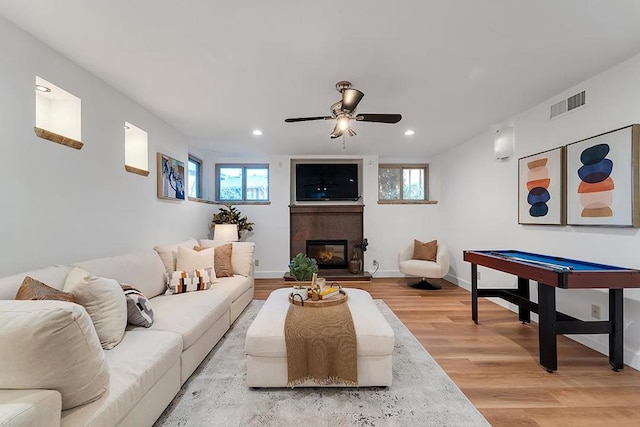 living room with ceiling fan and light hardwood / wood-style flooring