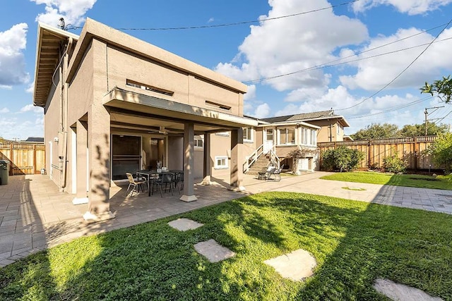 rear view of property with cooling unit, a patio, and a lawn