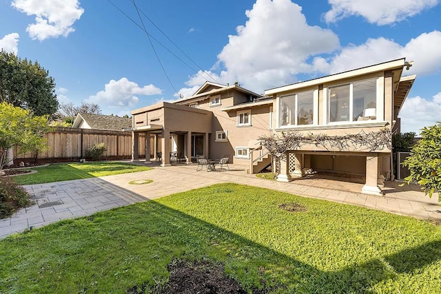 back of property with a yard and a patio area