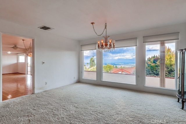 interior space featuring plenty of natural light, carpet floors, and an inviting chandelier