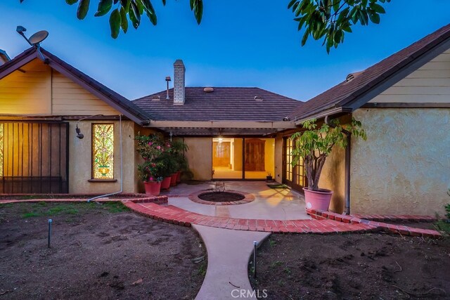 back house at dusk with a patio