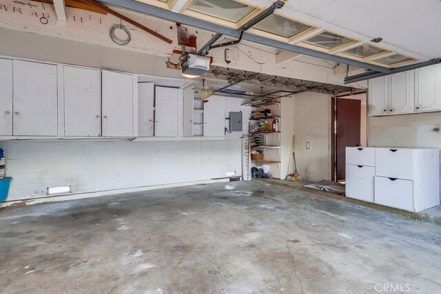 garage with a garage door opener and electric panel