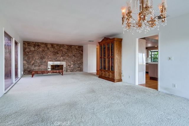 unfurnished living room featuring carpet flooring and a stone fireplace