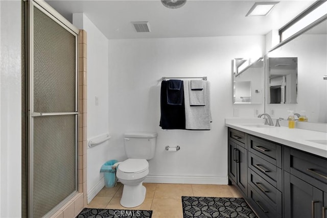 bathroom featuring tile patterned flooring, vanity, a shower with door, and toilet