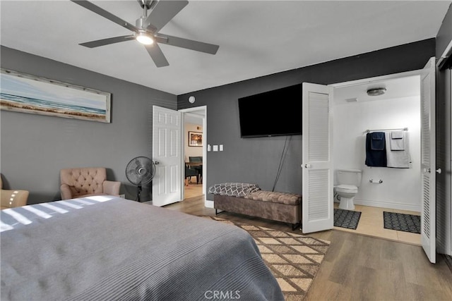 bedroom with ensuite bathroom, hardwood / wood-style floors, and ceiling fan