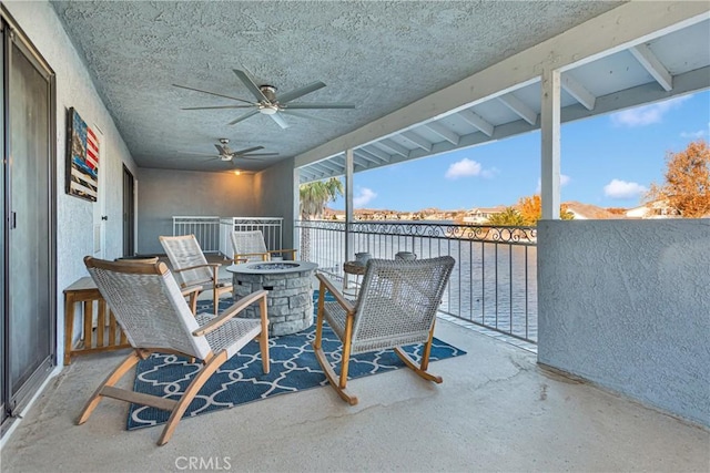 view of patio / terrace featuring ceiling fan, an outdoor fire pit, and a balcony