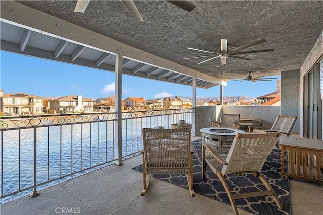 view of patio featuring a balcony, ceiling fan, and an outdoor fire pit