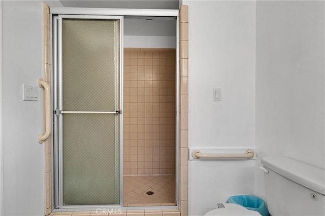 bathroom featuring an enclosed shower and toilet