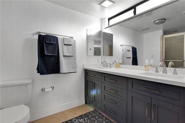 bathroom with tile patterned flooring, vanity, toilet, and walk in shower