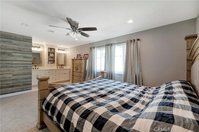 carpeted bedroom featuring ceiling fan and ensuite bath