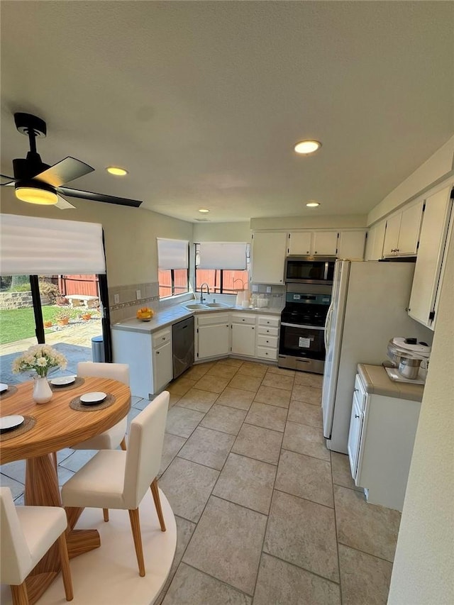 kitchen with sink, light tile patterned floors, white cabinetry, stainless steel appliances, and tasteful backsplash