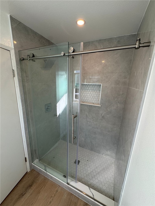 bathroom with hardwood / wood-style floors and a shower with door