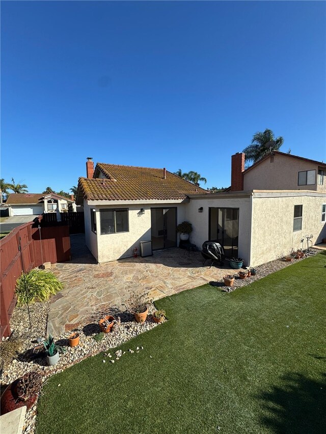 back of property featuring a patio and a yard