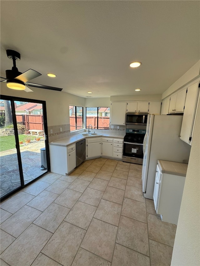 kitchen featuring tasteful backsplash, sink, white cabinets, and appliances with stainless steel finishes