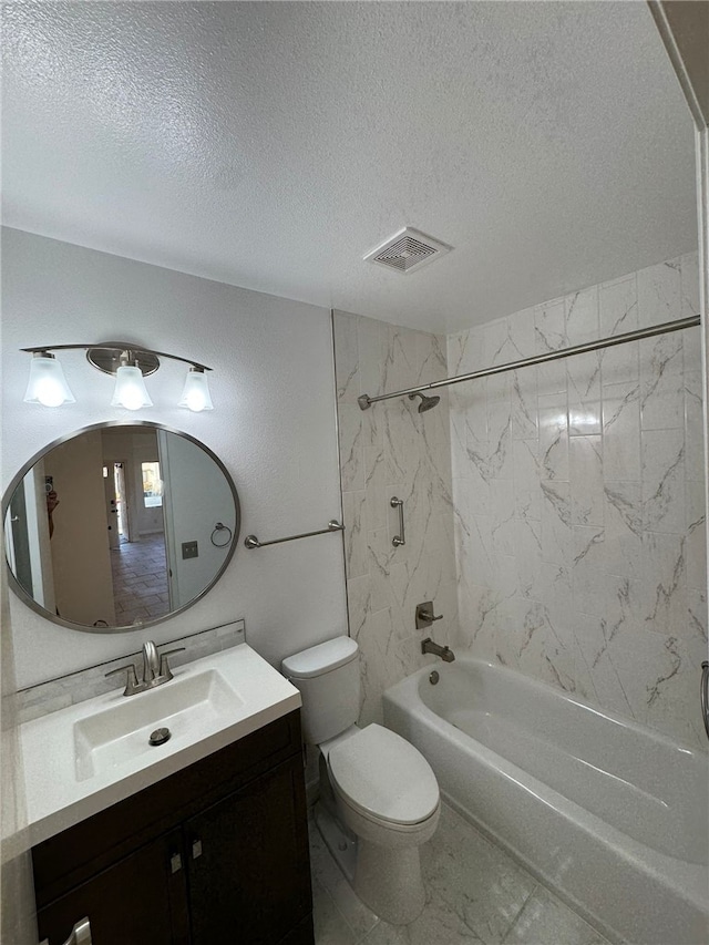 full bathroom with tiled shower / bath, vanity, a textured ceiling, and toilet