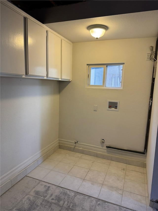 clothes washing area with gas dryer hookup, light tile patterned floors, hookup for a washing machine, and cabinets