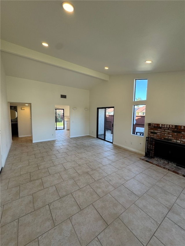 unfurnished living room featuring vaulted ceiling with beams, light tile patterned floors, a healthy amount of sunlight, and a brick fireplace