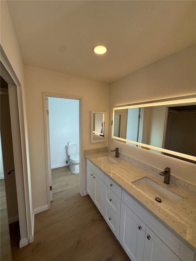 bathroom featuring vanity, hardwood / wood-style floors, and toilet