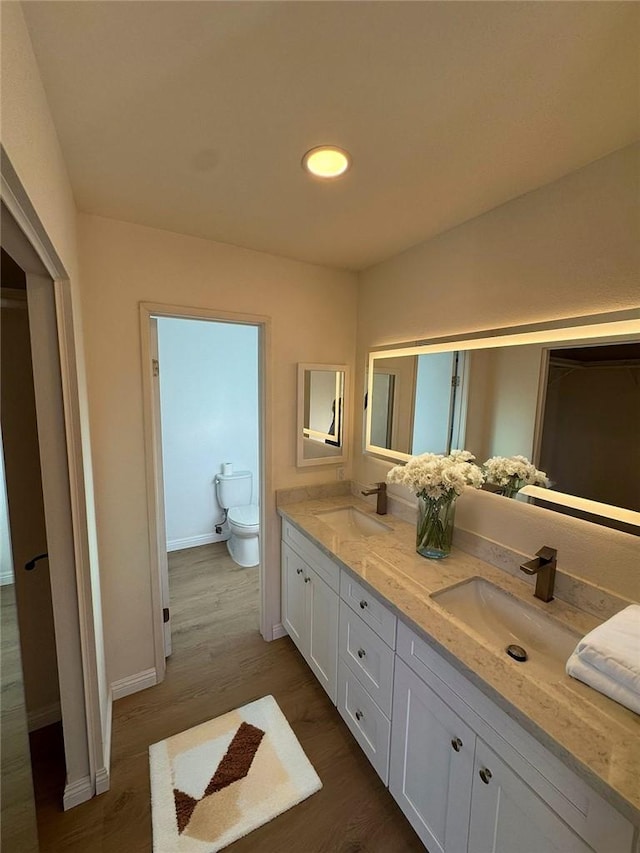 bathroom featuring hardwood / wood-style flooring, vanity, and toilet