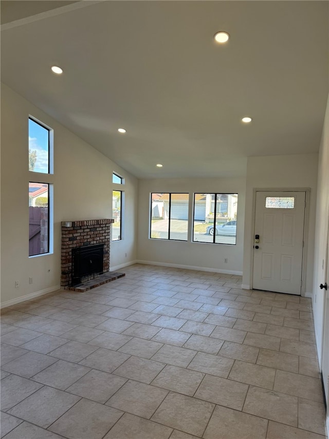 unfurnished living room featuring vaulted ceiling and a brick fireplace