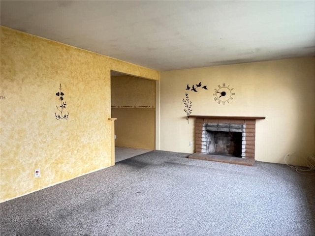 unfurnished living room featuring a brick fireplace and carpet flooring