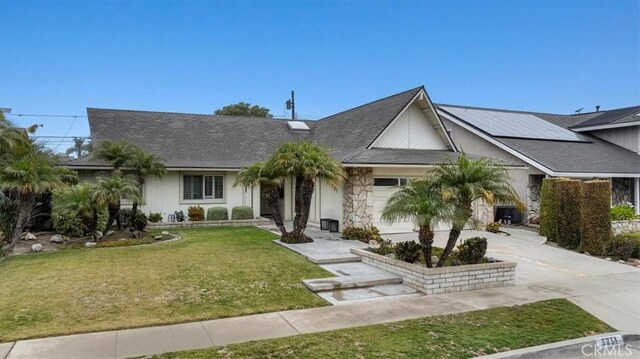 single story home featuring a front lawn and solar panels