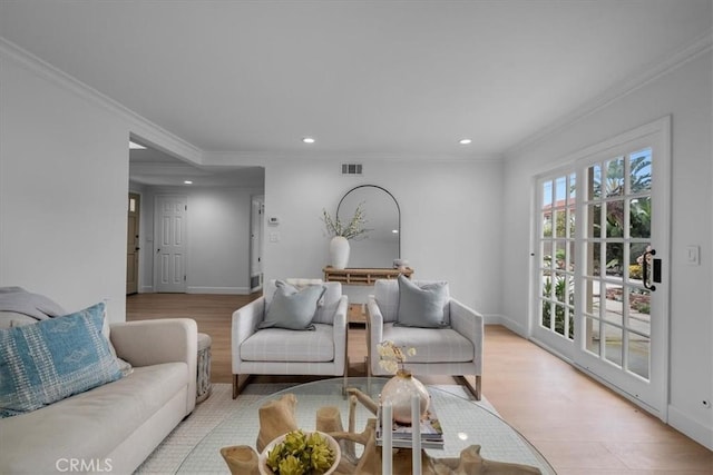 living room with crown molding and light hardwood / wood-style floors