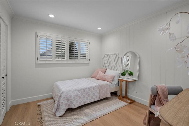 bedroom with ornamental molding and light wood-type flooring